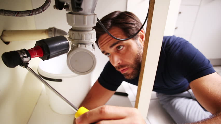 Handsome Caucasian plumber using screwdriver to fix sink and smiling to camera Royalty-Free Stock Footage #7740955