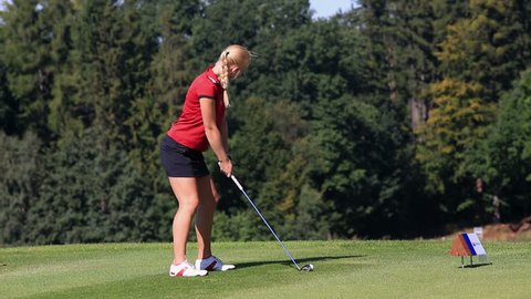Young female golf player hitting the ball