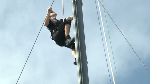 PORTO CERVO, ITALY – SEPTEMBER 7: Sailor climbing mast of sailing boat preparing the boat for a regatta on September 7, 2013 in Porto Cervo, Italy
