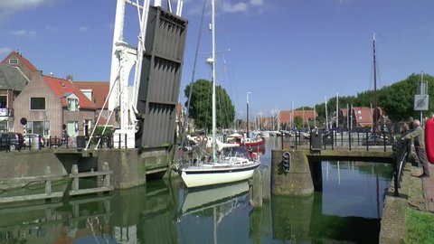 Enkhuizen,The Netherlands,-september 2014 province of North Holland :An old draw bridge opens for a sailing yacht in the historic harbour of Enkhuizen