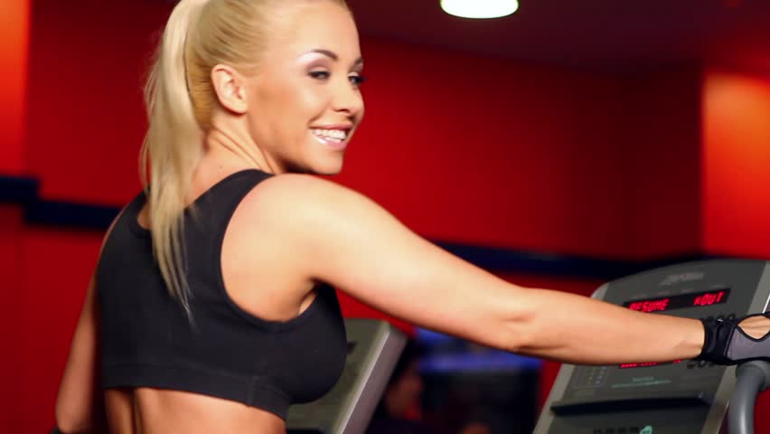 Beautiful sporty woman is exercising at the gym centre