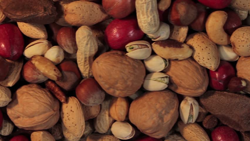 Nuts background with a mixed assortment of seeds and pecan with walnut brazil nut peanut,hazelnut pistachio almond and cashew as a healthy food symbol and nutritious protein and lifestyle icon. | Shutterstock HD Video #7766767