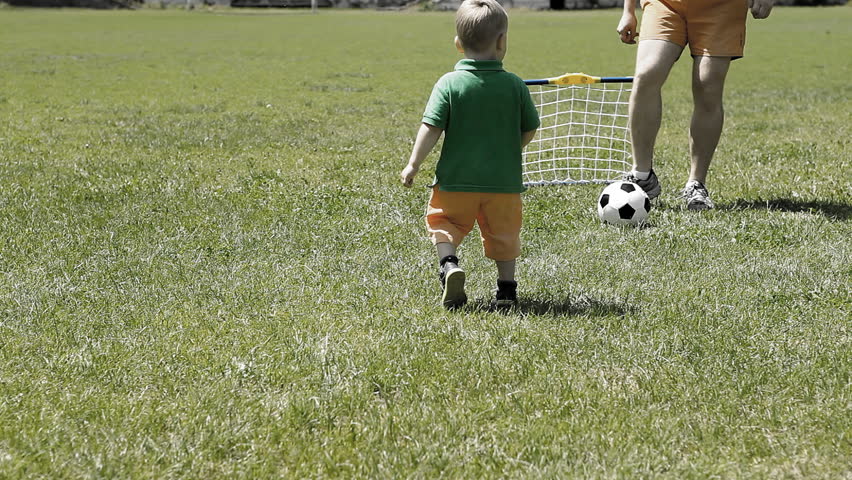Baby with father playing with soccer ball on the grass | Shutterstock HD Video #7768690