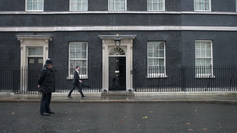 LONDON, UK - OCT 9: A police officer stands guard as a man arrives at 10 Downing Street in London on October 9, 2014