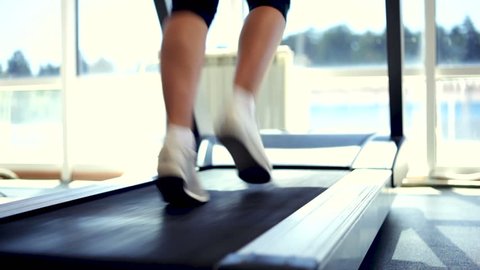 Woman running on a treadmill. Close-up shot/Running on a Treadmill