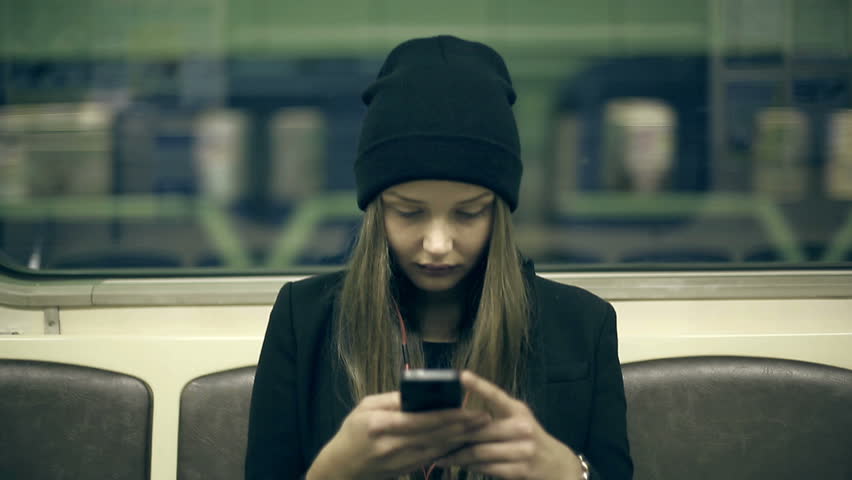 Teen girl rides the subway at night and used smartphone