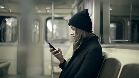 Teen girl rides the subway at night and used smartphone