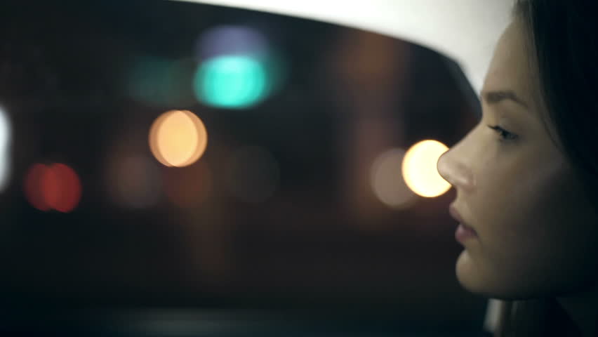 Girl rides in a taxi at night. Close up with bokeh Royalty-Free Stock Footage #7774129
