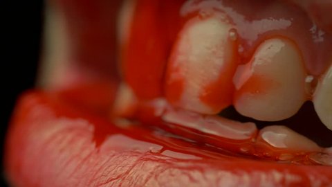 Closeup on the mouth of a bloody horrifying zombie in 4K resolution.