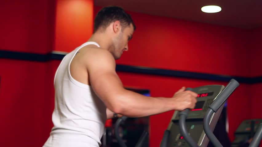 Handsome sporty man is exercising in gym center