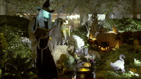 Witch on Halloween - Scary, Spooky Horror Scene at Night with Horrifying Witch Monster Casting Spell over Steaming Smoking Cauldron