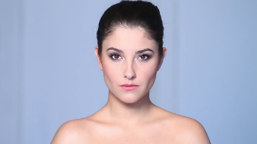 Beautiful young woman doing makeup 