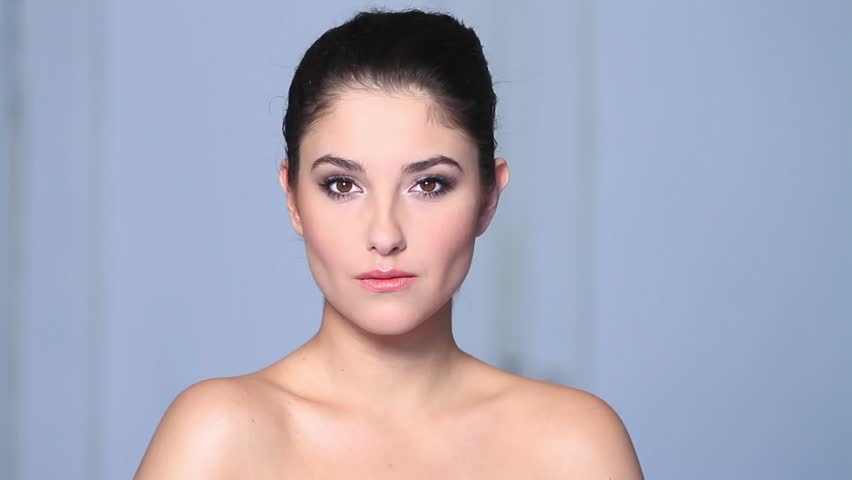 Beautiful young woman doing makeup 