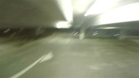 POV clip of an anonymous hand spinning a basketball continuously in an empty car park at night under a light