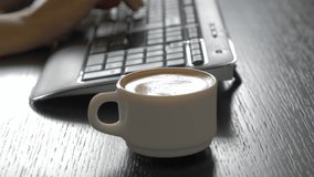 Typing on wireless keyboard with coffee cup nearby 4K 2160p UHD footage - Espresso coffee cup prepared for a break 4K 3840X2160 UHD video