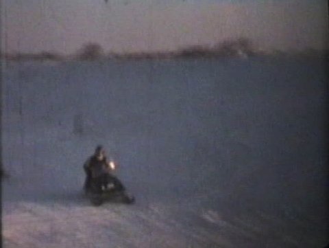 Two friends enjoy some time snowmobiling on a cold winter afternoon as the day turns to dusk.
