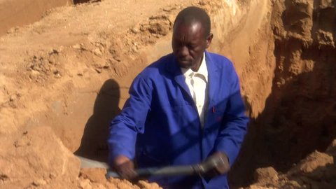 Gravedigger in a cemetery in Botswana digging a new grave,