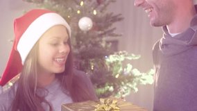 Christmas gift. Happy young man surprising his girlfriend with a gift box for Happy New Year. Happy family near christmas tree. Slow motion video footage high speed camera 240 fps. Slowmo 1080 HD 1080