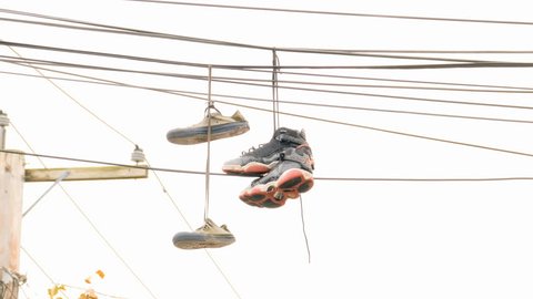 Sneakers hanging from telephone wire in the city is a symbol for a drug dealer or gang turf 