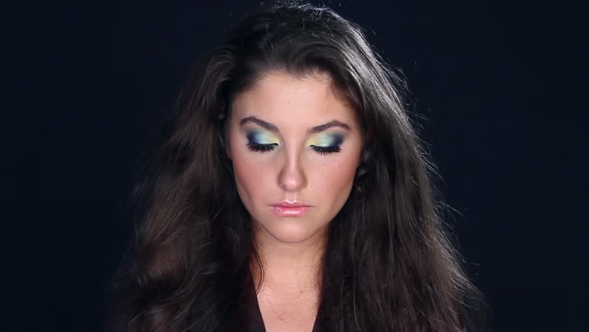 Portrait of beautiful young woman on black background  