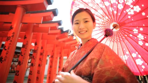 Travel tourism Japan happy young Asian Japanese female traditional red kimono parasol portrait promotional welcome outdoors location
