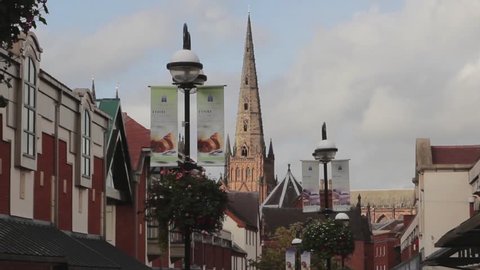 The Spire of Lichfield Cathedral Towering above Roof of Shopping Mall showing blue sky and drifting clouds - Lichfield Town Centre

Location: Lichfield, Staffs, England, UK

Source: Canon 5DMkiii