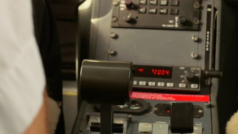 Pilot rests hand on throttle power control in cockpit