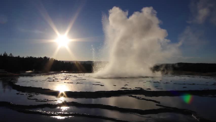 Geyser erupts at sunset on the Firehole Lake Drive, Yellowstone National Park.