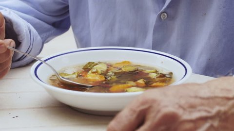 retired old man eating soup outdoor: 4k footage sadness, bored, poor