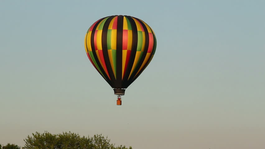 A hot air balloon gently glides through the air on a summer evening.