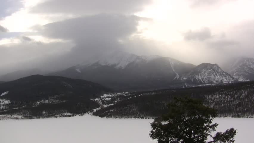 Winter Storm Brewing / There is a winter storm brewing over this frozen lake in the distance. Shot features great natural audio in this unique look at the winter mountain scape.