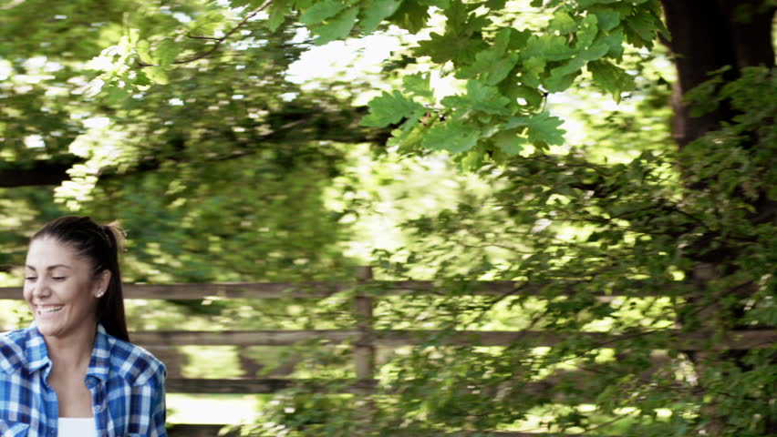 Boy meeting girl with flowers and happy couple cycling down a country road bicycle lane, steadicam shot.