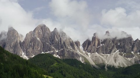 Wide shot of clouds passing over mountains range / Dolomites, Italy