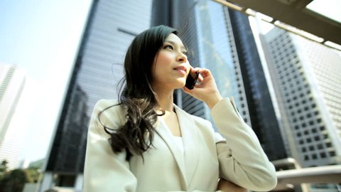 Ambitious ethnic Chinese girl advertising business manager outdoors downtown buildings wireless hotspot smart phone connection