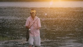 Slow motion clip of a man fishing with sunset right behind him. stock video clip full hd