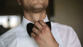 The man straightens his tie. Close up