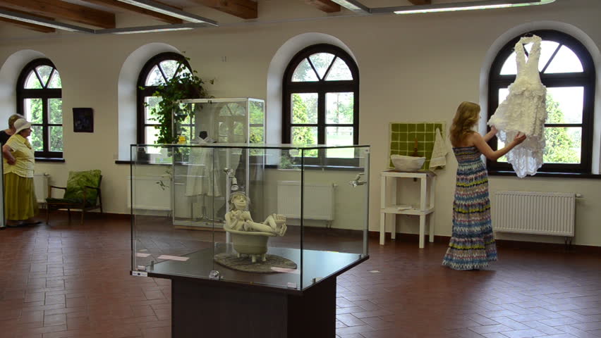 KAIRENAI, LITHUANIA - MAY 24, 2014: Variuos retro rural clothes and accessories in indoor exhibition and people tourists on May 24, 2014 in Kairenai, Lithuania.
