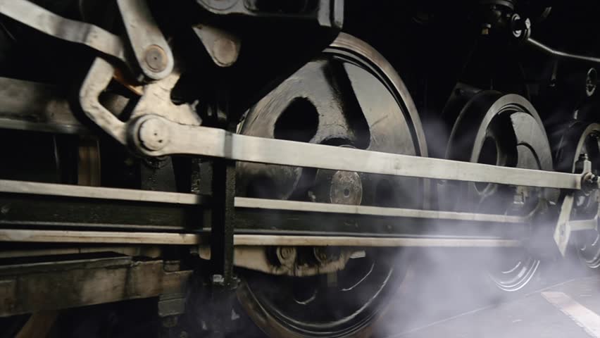 Steam engine train wheels passing in slow motion. historical technology background
