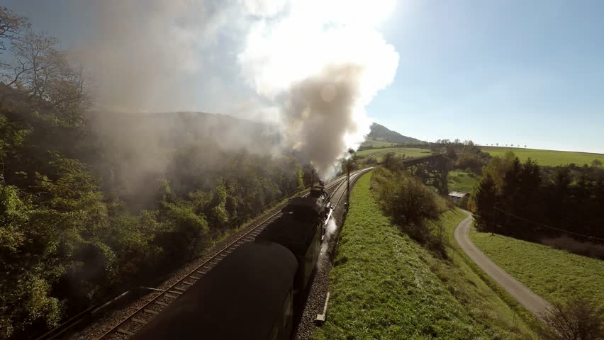 Flying over steam train at sunshine. old locomotive. heavy steam smoke background