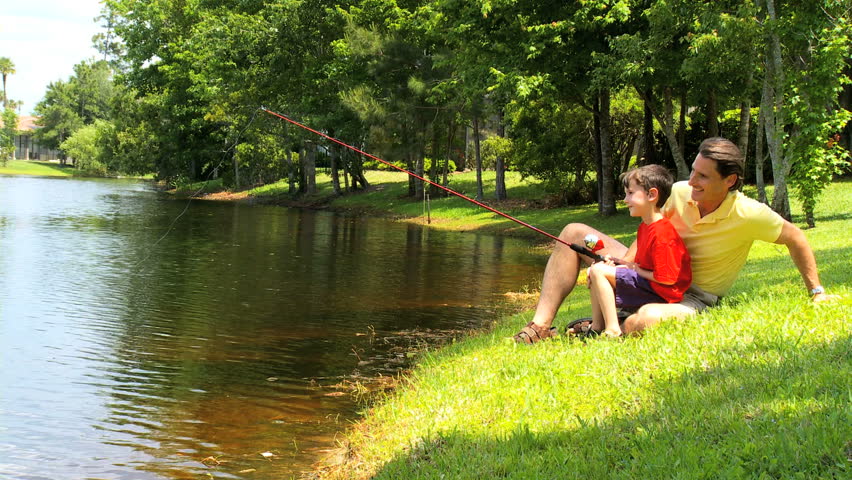 Father enjoying time with his young son while learning new fishing skills Royalty-Free Stock Footage #789817