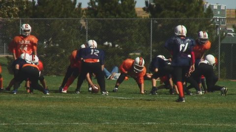 Youth football teams enjoy full contact game-passing play; HD, audio 