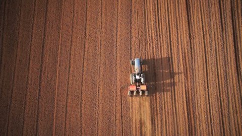 Aerial of tractor on harvest field (top view from height)