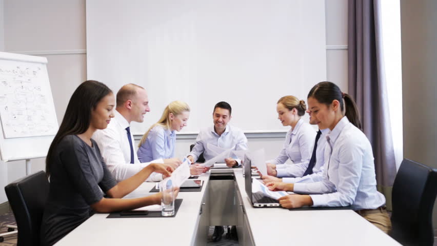 Business, teamwork, people and technology concept - smiling business team with laptop computer, papers and smartphone making thumbs up gesture in office | Shutterstock HD Video #7902121