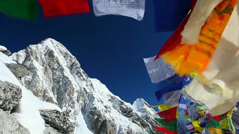 Buddhist colorful prayer flags blow by the wind in the mountains in Himalayas, Nepal.