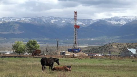 MORONI, UTAH - OCT 2014: Oil exploration well rural farming community. Gas and oil pricing at near record price exploration continues to areas never before explored. Farm land used for industrial use.