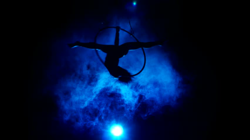 Aerial acrobat woman on circus stage. Silhouette on a blue background.