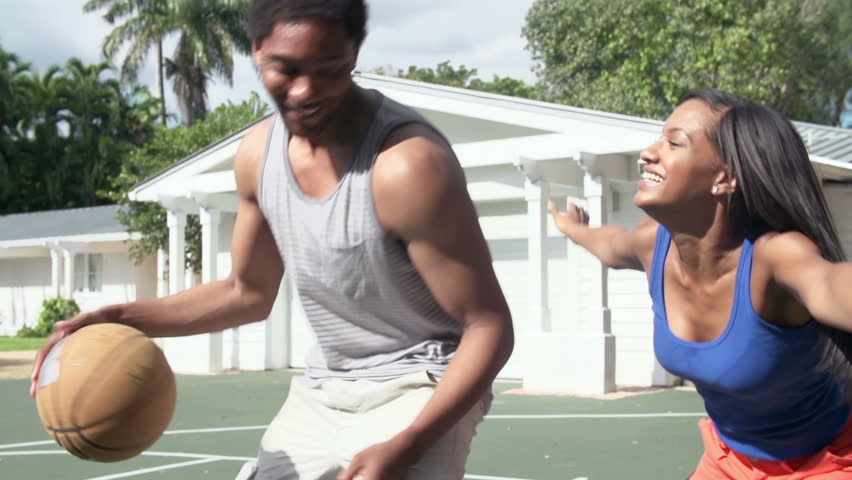Slow motion sequence of couple playing basketball at home - man scores basket. Shot on Sony FS700 at frame rate of 100fps