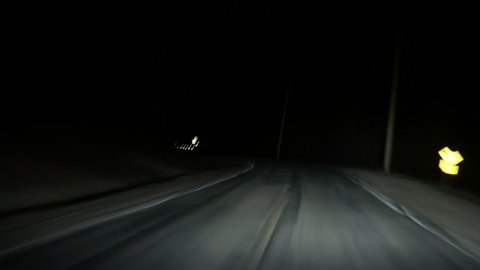 Driving down rural highway in pitch black night timelapse loop. Running from the law down a dark country highway, twisting and turning left and right. The night is dark and the road is long. Loop