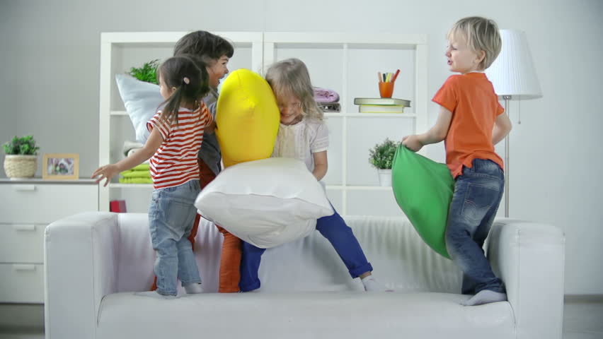 Four kids playing on sofa pillow fighting  Royalty-Free Stock Footage #7920406