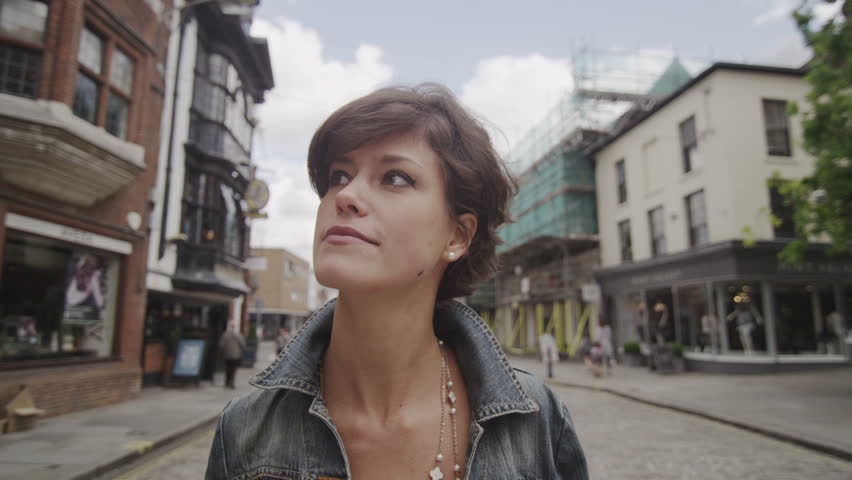 Woman window shopping in European town, UK.  Happy young lady browsing the city shops.